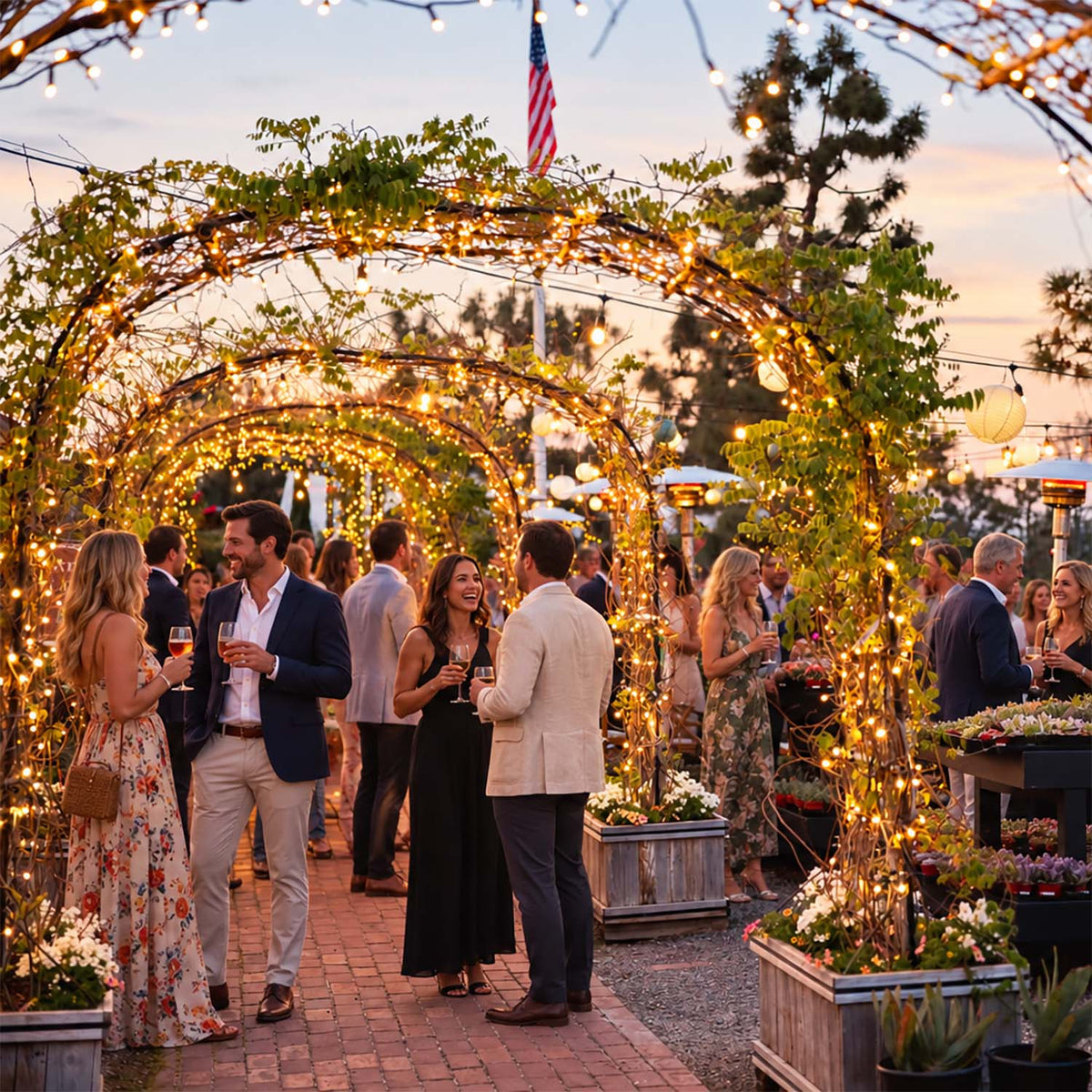 Guests celebrating outdoors beneath garden lights at Roger's Gardens in Corona del Mar